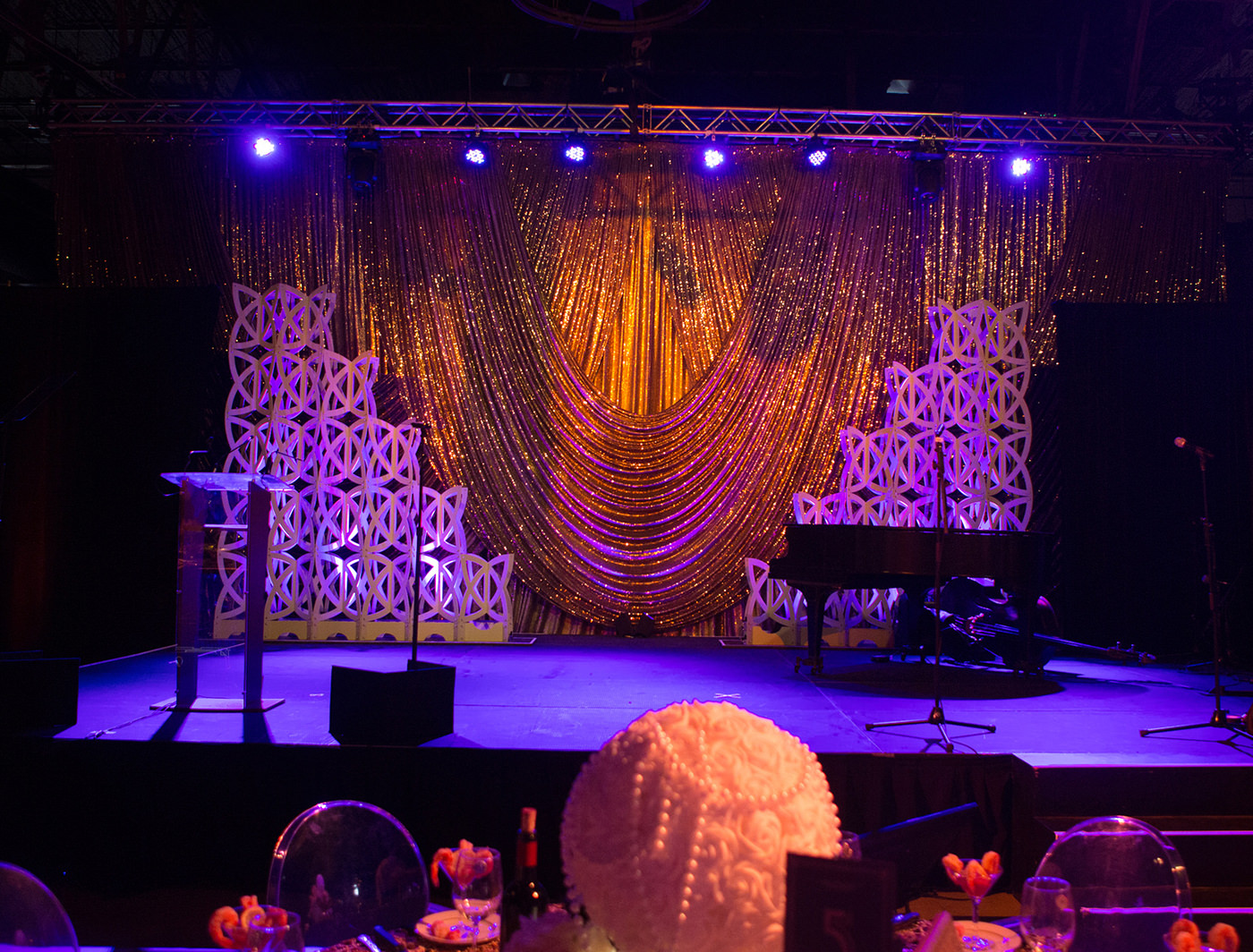 GOLD SPARKLE DOT ON STAGE BEHIND KNOT PANELS
