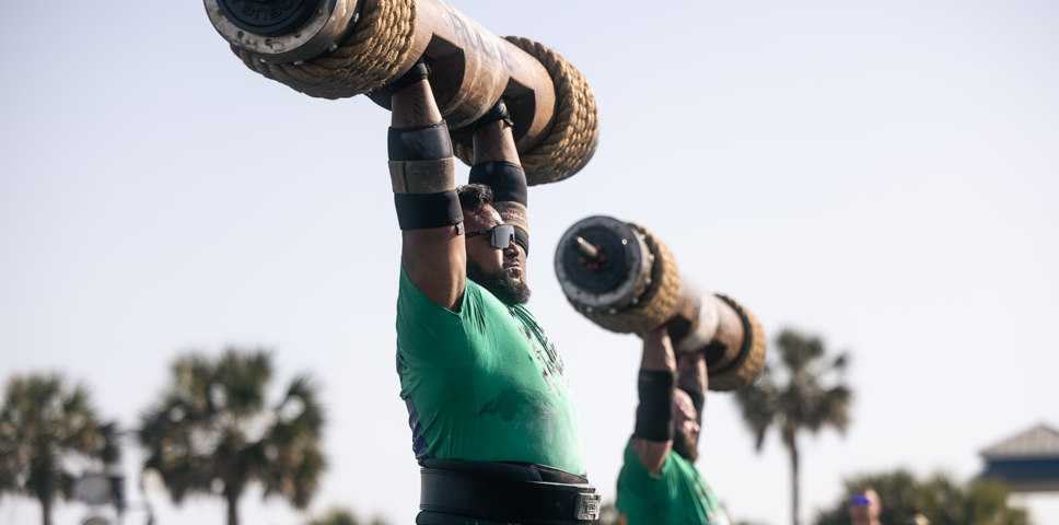 two men lifting giant weights over their heads