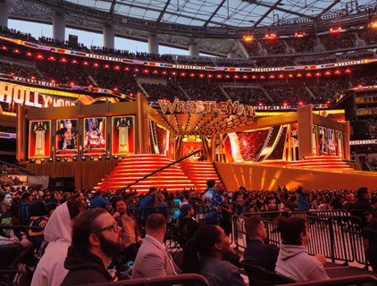 red and gold big wrestlemania stage with people in front of it