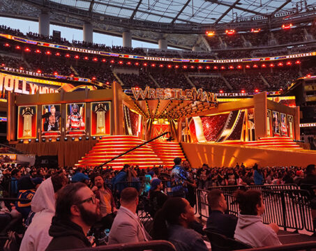 red and gold big wrestlemania stage with people in front of it