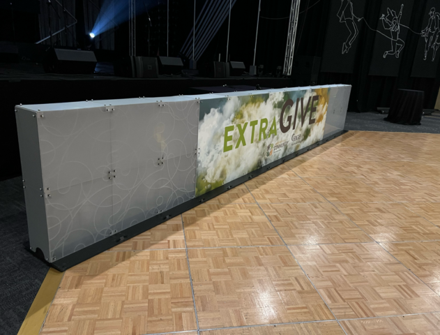 ATOMIC SuperLever panels make a short SuperWall with cusotm signage that reads "Extra Give"