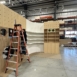 worker standing on a ladder while building custom set in workshop