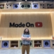 man with folded arms in front of 'made on youtube" display
