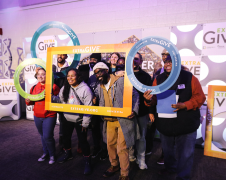 group of people holding custom frames in front of benefit display