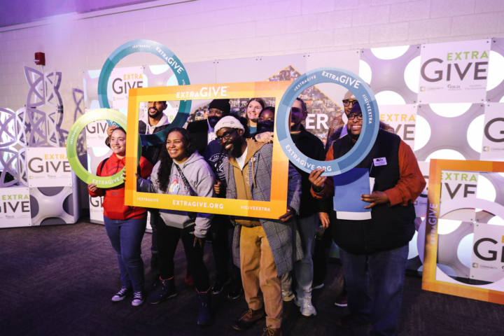group of people holding custom frames in front of benefit display