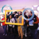 group of people holding custom frames in front of benefit display