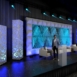 Rendering of a Shell modular scenic wall installed on a live event stage with presenters and scenic elements in front.