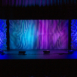 Full-width Shell and Pixel modular scenic wall installed on stage with blended blue and purple lighting.