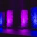 Pixel modular scenic panels installed on stage with strong vertical purple lighting columns.
