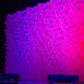 Full-width Pixel modular scenic wall installed on a stage with pink and blue gradient lighting.