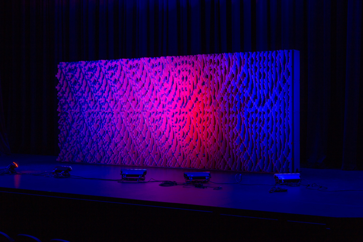 Pixel modular scenic wall on stage with blended purple and blue lighting.