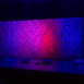 Pixel modular scenic wall on stage with blended purple and blue lighting.