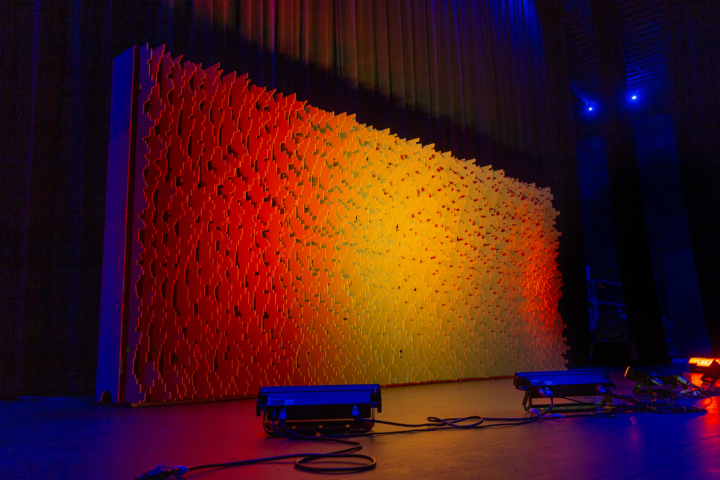 Wide angled stage installation of Pixel modular scenic panels with warm color wash lighting.