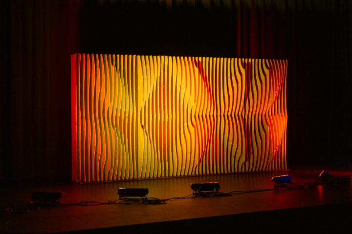 Full-width Shell modular scenic wall with warm orange lighting.