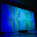 Angled view of Shell modular scenic wall installed on stage with colored lighting.
