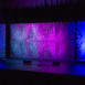 Full-width Pixel modular scenic wall installed on stage with blended purple, red, and blue lighting.
